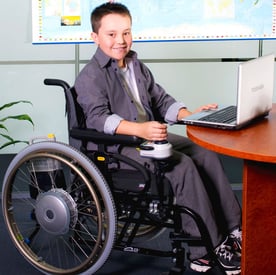 Kid in wheelchair with power assist device